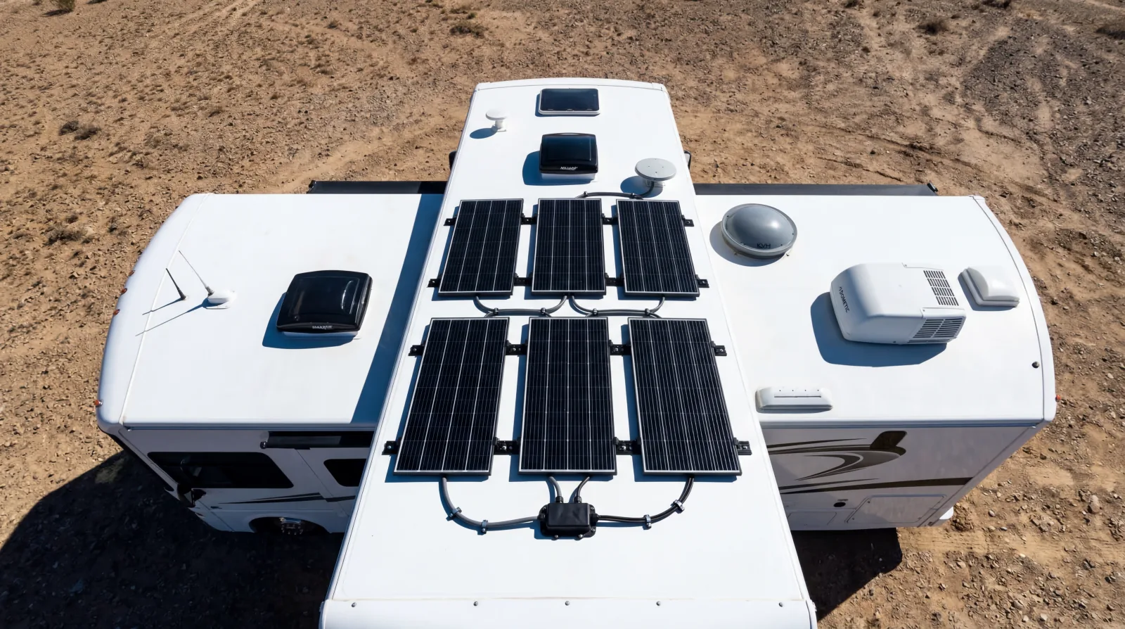 Aerial drone view of six solar panels installed in a 2x3 grid on an RV roof in the desert